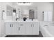 Bathroom featuring double sink vanity with modern fixtures, sleek white cabinetry, and a soaking tub at 5213 Giallo Vista Ct, North Las Vegas, NV 89031