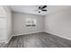 Neutral bedroom with wood-look floors, ceiling fan, and natural light streaming through the window at 5213 Giallo Vista Ct, North Las Vegas, NV 89031