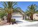 Inviting single-story home featuring desert landscaping with mature palm trees and an attached two-car garage at 5213 Giallo Vista Ct, North Las Vegas, NV 89031
