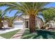 Inviting single-story home featuring desert landscaping with mature palm trees and an attached two-car garage at 5213 Giallo Vista Ct, North Las Vegas, NV 89031