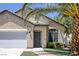 Inviting single-story home featuring desert landscaping with mature palm trees and an attached two-car garage at 5213 Giallo Vista Ct, North Las Vegas, NV 89031
