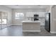 Bright, modern kitchen featuring stainless steel appliances, white cabinets, quartz countertops and light grey wood floors at 5213 Giallo Vista Ct, North Las Vegas, NV 89031