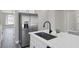 Close-up of island sink with stainless steel refrigerator and view to living room at 5213 Giallo Vista Ct, North Las Vegas, NV 89031