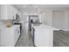 Stylish kitchen features stainless steel appliances, quartz countertops, white cabinets, and grey wood floors at 5213 Giallo Vista Ct, North Las Vegas, NV 89031