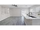 Open-concept kitchen and living space with gray vinyl flooring, white countertops, and stainless steel appliances at 5213 Giallo Vista Ct, North Las Vegas, NV 89031