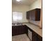 Galley kitchen with stainless steel sink, dark cabinets, and white dishwasher at 5655 E Sahara Ave # 1037, Las Vegas, NV 89142