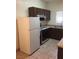 The kitchen has tile floors, standard appliances and dark cabinets at 5655 E Sahara Ave # 1037, Las Vegas, NV 89142