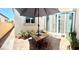 Inviting back patio with umbrella-covered table, chairs, and potted plants at 6009 La Coste St, North Las Vegas, NV 89081