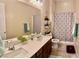 Bathroom featuring a double sink vanity with modern fixtures, a bathtub, and a decorative mirror at 6009 La Coste St, North Las Vegas, NV 89081