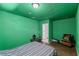 Unique bedroom with vibrant green walls, wood-look floors, and minimalist style with a chair at 6017 Natures Dr, Las Vegas, NV 89122