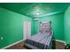 Simple bedroom showcasing green walls, white sliding closet doors, and a comfortable bed with a patterned blanket at 6017 Natures Dr, Las Vegas, NV 89122