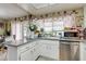 Bright kitchen features granite countertops, stainless steel appliances, and floral accents at 604 N Torrey Pines Dr, Las Vegas, NV 89107