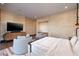 Serene bedroom with a sitting area, TV, and neutral decor at 609 Sleeping Dragon Dr, Henderson, NV 89012
