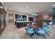 Open-concept living space with a modern kitchen, dining area with blue chairs, and fireplace at 609 Sleeping Dragon Dr, Henderson, NV 89012