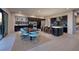 Open-concept living space featuring a kitchen, dining area with blue chairs, and access to outdoor dining at 609 Sleeping Dragon Dr, Henderson, NV 89012