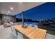 Outdoor dining area with a view of the pool and city lights at 609 Sleeping Dragon Dr, Henderson, NV 89012