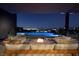 Inviting outdoor patio features a cozy fire pit and comfortable seating with views of the pool and city lights at 609 Sleeping Dragon Dr, Henderson, NV 89012