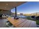 Beautiful outdoor dining area and sitting area with views of pool and city at 609 Sleeping Dragon Dr, Henderson, NV 89012
