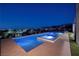 Backyard oasis featuring a modern pool and spa with city views at night at 609 Sleeping Dragon Dr, Henderson, NV 89012