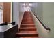 Elegant staircase featuring wood steps, modern railing, and ambient lighting at 609 Sleeping Dragon Dr, Henderson, NV 89012