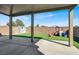 Spacious backyard with covered patio, artificial grass, playset, and storage shed at 6618 Palm Branch St, North Las Vegas, NV 89086