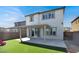 Home's back exterior shows well manicured backyard, artificial turf, and covered patio at 6618 Palm Branch St, North Las Vegas, NV 89086