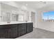 Bathroom with double sinks, dark wood cabinets, tile floors, and natural light at 6618 Palm Branch St, North Las Vegas, NV 89086
