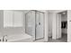Bright bathroom with tub, glass enclosed shower, and an open walk-in closet at 6618 Palm Branch St, North Las Vegas, NV 89086
