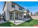 Home's back exterior shows well manicured backyard, artificial turf, and covered patio at 6618 Palm Branch St, North Las Vegas, NV 89086