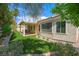 Well-maintained backyard with artificial grass, a covered patio, and lush landscaping around the perimeter at 8541 Highland View Ave, Las Vegas, NV 89145