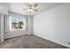 Bright bedroom featuring a ceiling fan, plush carpeting, and a window offering a view of palm trees at 8541 Highland View Ave, Las Vegas, NV 89145
