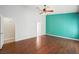 This primary bedroom boasts wood floors, a ceiling fan, and a teal accent wall at 8541 Highland View Ave, Las Vegas, NV 89145