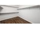 A clean, spacious walk-in closet with ample shelving and wood flooring at 8541 Highland View Ave, Las Vegas, NV 89145