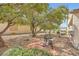 Relaxing backyard space with mature trees, a grill, and a paved area at , Henderson, NV 89044