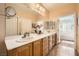 This bright bathroom features double sinks with wood cabinets and decorative accents at , Henderson, NV 89044