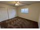 Bedroom featuring neutral carpet and ceiling fan with double door closets and a window at 101 Luna Way # 145, Las Vegas, NV 89145