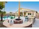 Beautiful backyard featuring a pool, covered patio, built-in grill, and a cozy fire pit at 10243 Cowboys Dream St, Las Vegas, NV 89131