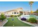 Lush backyard with a putting green, covered patio, pool, and well-maintained landscaping at 10243 Cowboys Dream St, Las Vegas, NV 89131