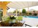 Beautiful backyard featuring a covered patio, a sparkling pool, and lush landscaping at 10243 Cowboys Dream St, Las Vegas, NV 89131