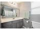 A bathroom with neutral grey walls, a framed mirror, a toilet, and a vanity with cabinet storage at 10243 Cowboys Dream St, Las Vegas, NV 89131