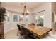 Bright dining room with modern chandelier, wooden table, and view of the backyard at 10243 Cowboys Dream St, Las Vegas, NV 89131