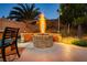 Outdoor fire pit in a backyard, featuring a circular stone design and surrounded by mature landscaping for cozy evenings at 10243 Cowboys Dream St, Las Vegas, NV 89131