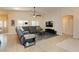 Comfortable living room with tile floors, a sectional sofa, a ceiling fan, and ample natural light from the windows at 10243 Cowboys Dream St, Las Vegas, NV 89131