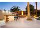 Outdoor kitchen and fire pit with seating, perfect for entertaining in a beautifully landscaped backyard setting at 10243 Cowboys Dream St, Las Vegas, NV 89131
