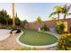 Landscaped backyard featuring a putting green with sand trap and desert plants at 10243 Cowboys Dream St, Las Vegas, NV 89131
