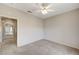 Bedroom with a ceiling fan, neutral walls and carpet flooring, leading to hallway at 10636 Argents Hill Dr, Las Vegas, NV 89134
