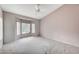 Spacious bedroom featuring a ceiling fan, a bay window and neutral walls and carpet at 10636 Argents Hill Dr, Las Vegas, NV 89134