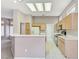 Well-lit kitchen with light wood cabinets, modern appliances, and white tiled floors at 10636 Argents Hill Dr, Las Vegas, NV 89134