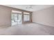 Bright living room boasts a ceiling fan, plush carpet, and sliding glass doors to the backyard at 10636 Argents Hill Dr, Las Vegas, NV 89134