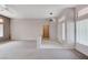Spacious living room area with carpet flooring, white walls, and a ceiling fan at 10636 Argents Hill Dr, Las Vegas, NV 89134
